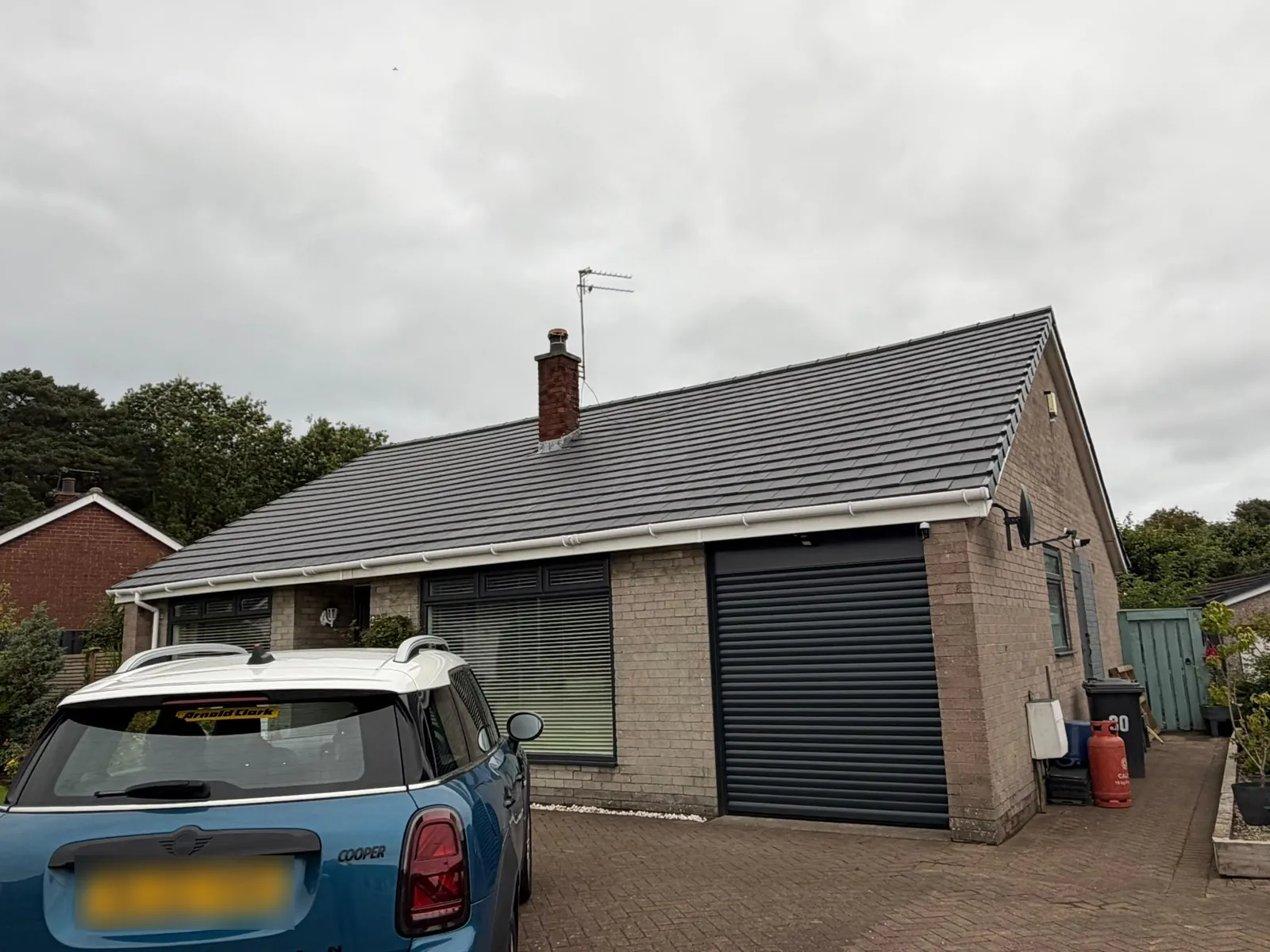 New grey tiled roof and white guttering on a bungalow